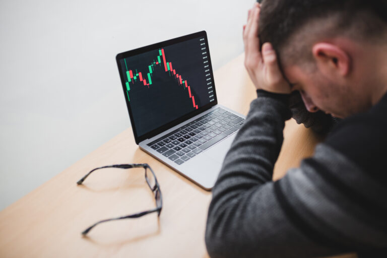 person in front of computer with stock chart going down getty