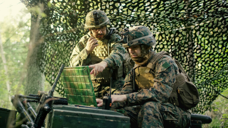 two soldiers using a laptop computer