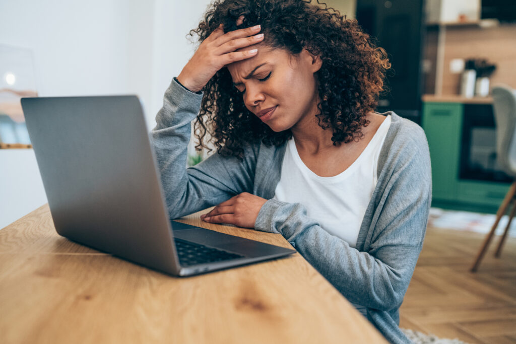 frustrated investor closes eyes in front of computer