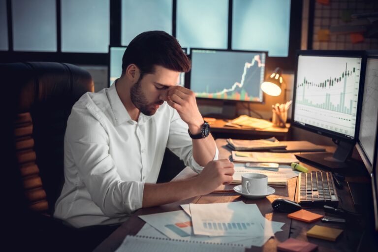 a frustrated investor reviewing multiple charts and reports