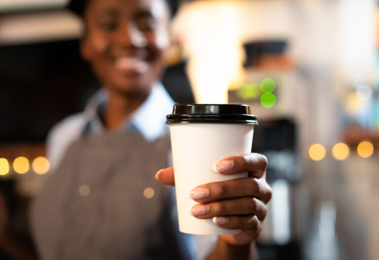 employee handing over cup of coffee