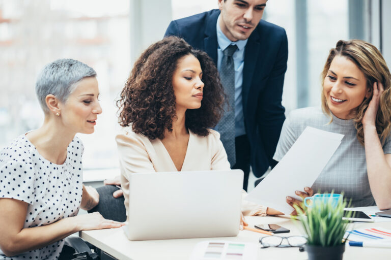 gettyimages group of business people discuss something around a table