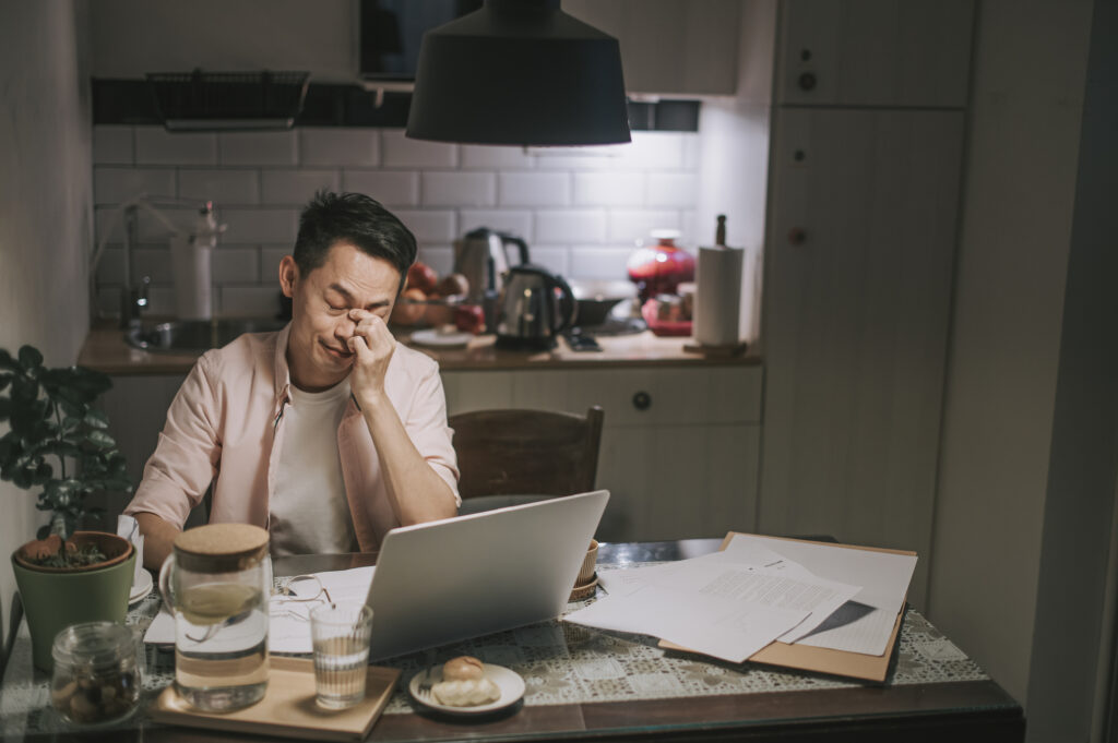 man with worried look in front of laptop 2022