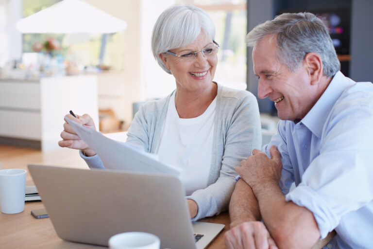 senior couple smiling laptop gettyimages 495809094