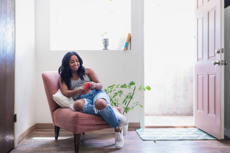 young adult holding phone in chair Z4cjA2Q