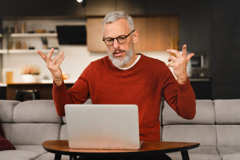 22 09 29 a person looking at a laptop raising their arms as if frustrated gettyimages 1359039717 mf dload