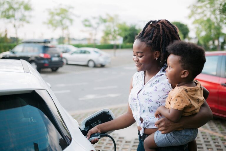 Mother holding her son while charging her electric vehicle efsx05B