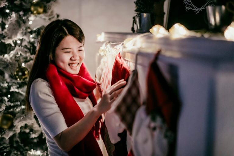 Woman hanging Christmas stocking over fireplace. nzUpAbL