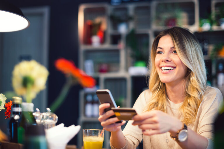 person holds smartphone and credit card