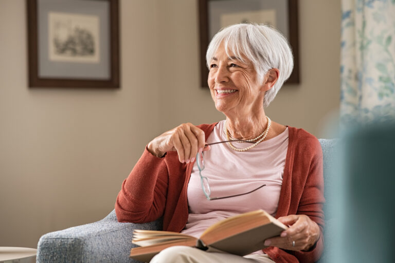 senior woman smiling book gettyimages 1316201778