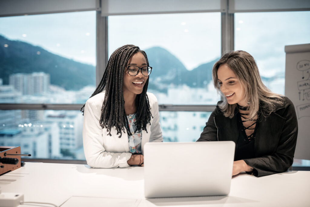 two business people collaborate in an office with the mountains of rio de janeiro in the background