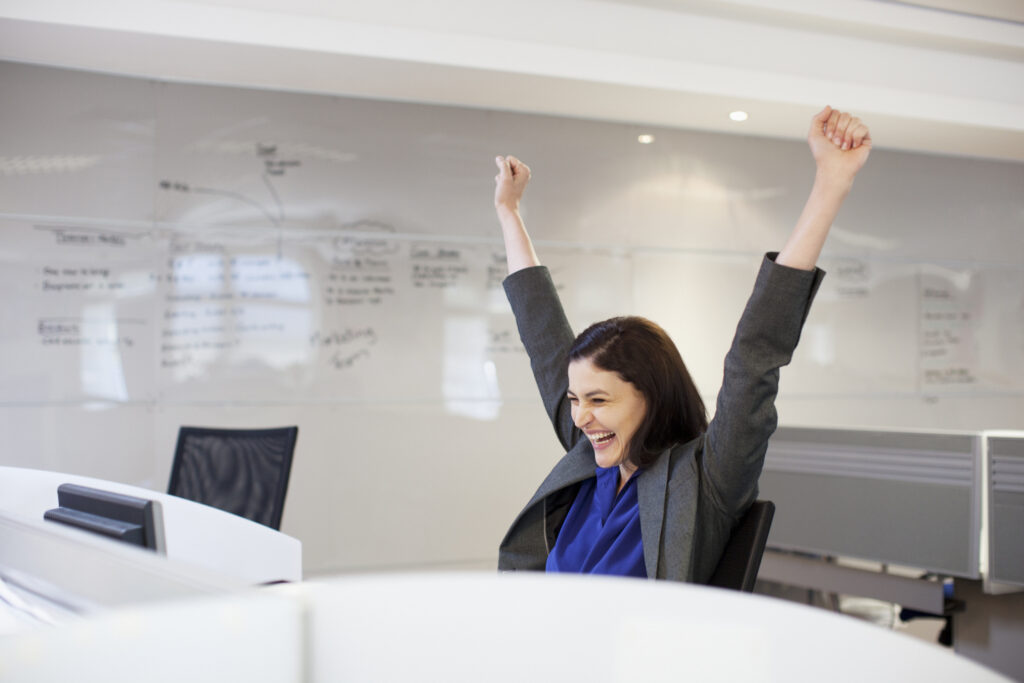 businessperson celebrates in an office setting