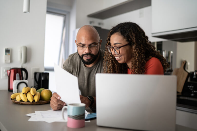 two investors consult papers and laptop