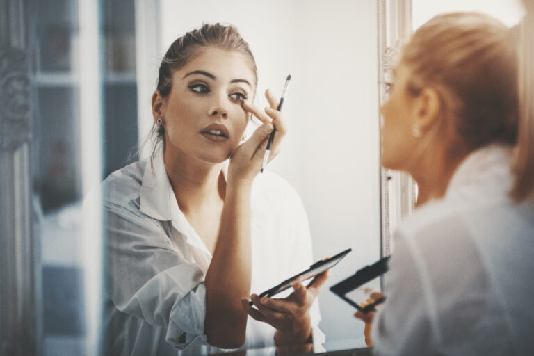 lady does makeup in mirror