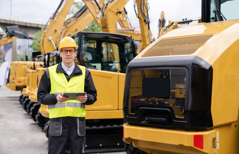 person standing in front of construction vehicles