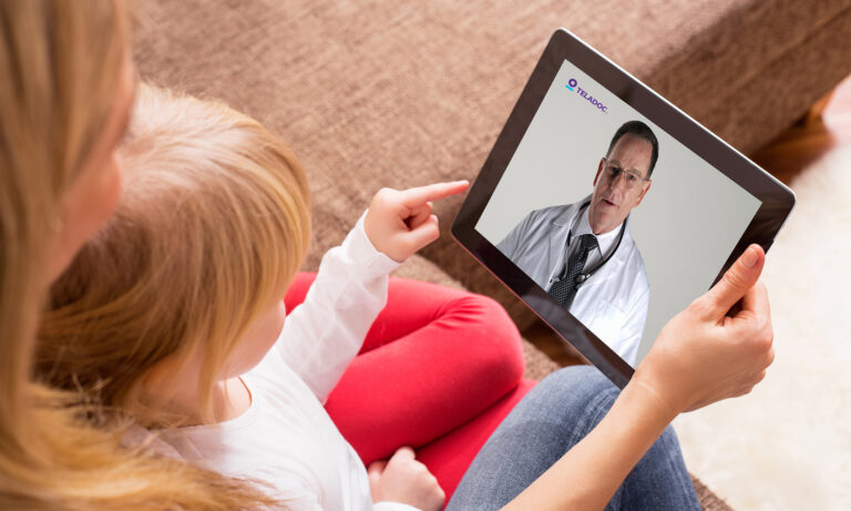 person using tablet for doctor visit for child with teladoc health logo on screen teladoc