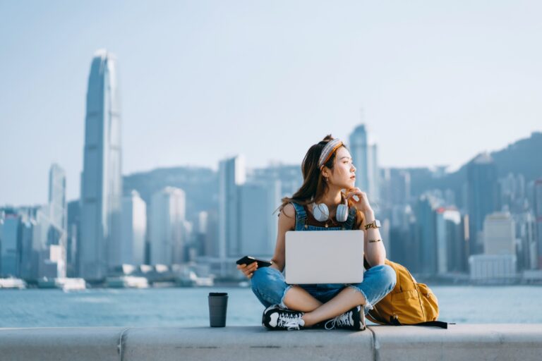 a person using a laptop computer outside in hong kong