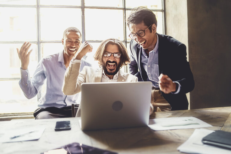 investors celebrate around laptop