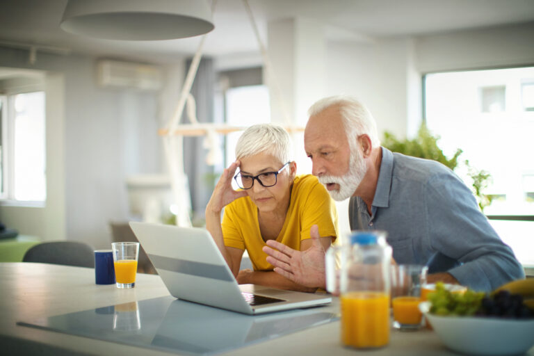 worried couple looking at laptop