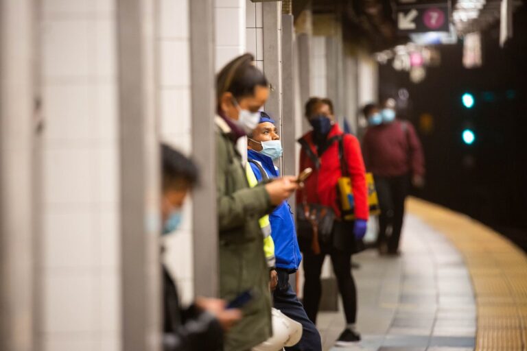 Masked commuters on platform