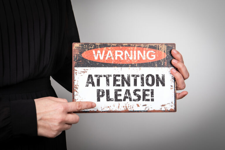 24 09 26 a person holding a sign that says warning attention please mf dload gettyimages 1639158401 1201x800 5b2df79