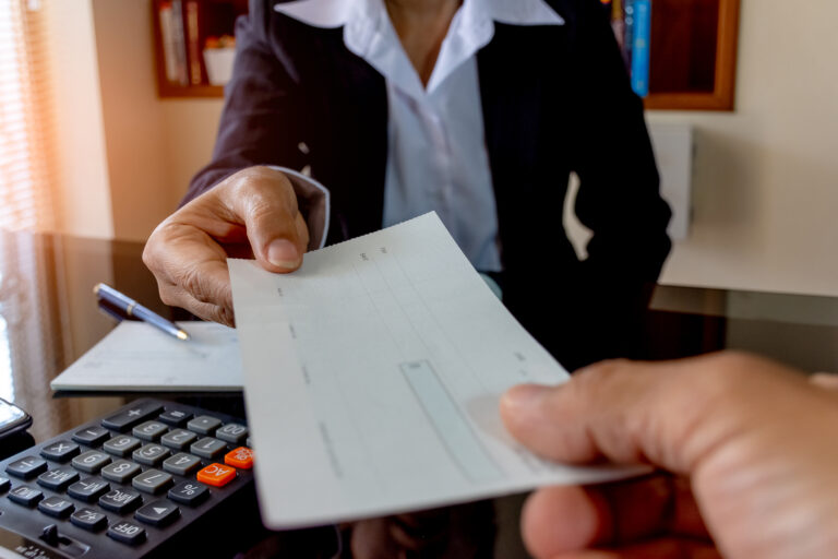 a person handing a check to another person
