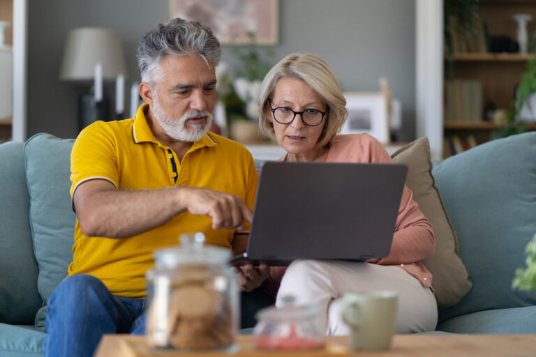 couple discussing something on laptop in living room