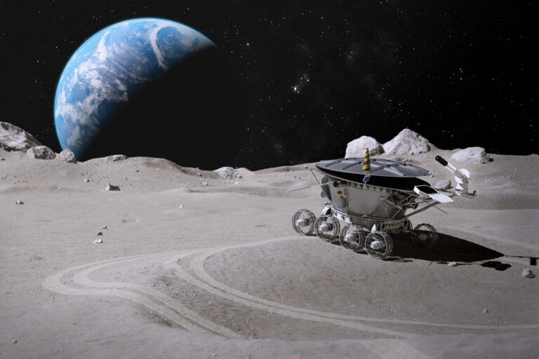 rover driving around the moon with the earth in the background